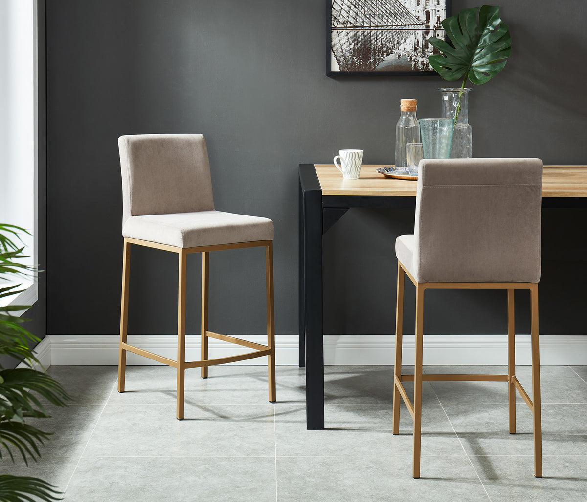 Two Diego 26-inch grey velvet counter stools with aged gold metal legs styled in a dining room